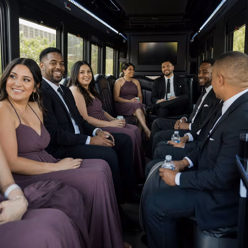 Wedding guests seated inside a San Antonio party bus