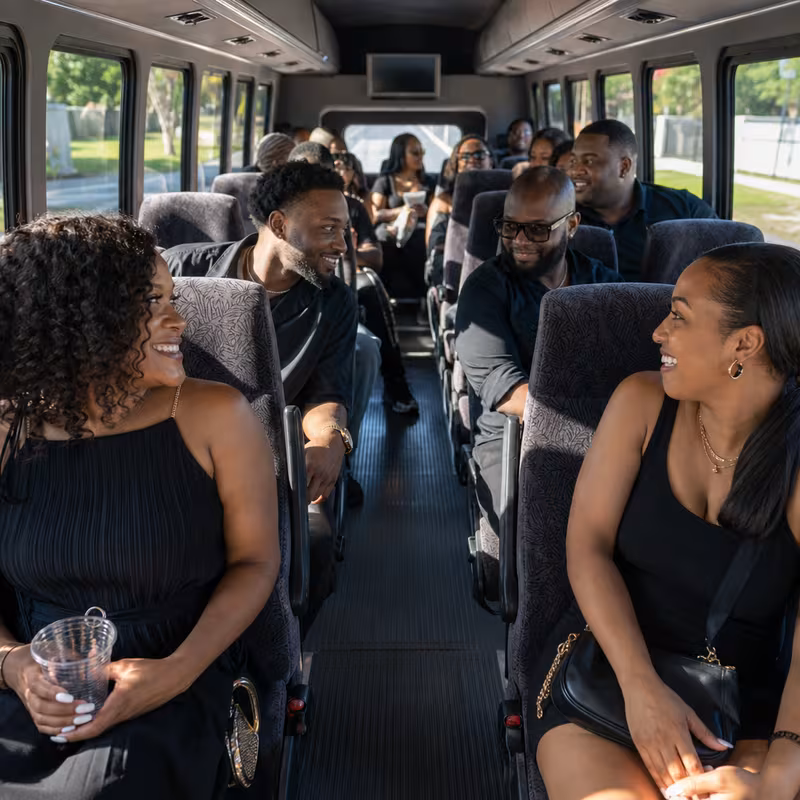 Group boarding a white charter bus for Private Event Transportation transportation in San Antonio