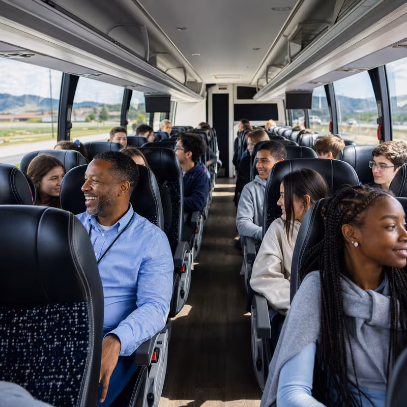 Group boarding a white charter bus for School Transportation transportation in San Antonio