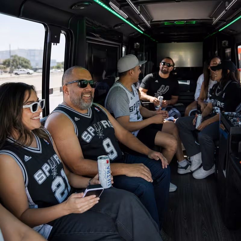 Group boarding a white charter bus for Sporting Event Transportation transportation in San Antonio